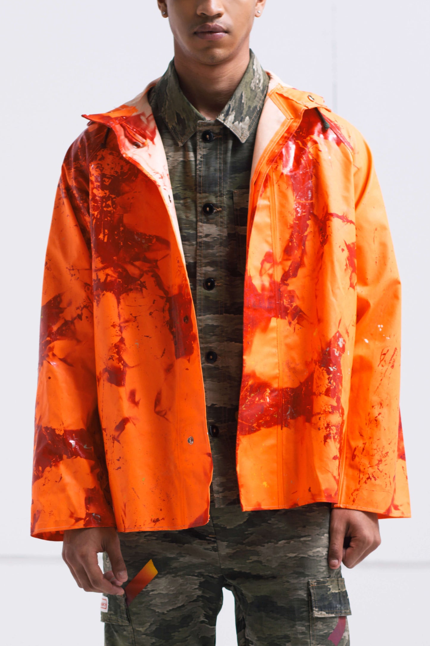 ORANGE RAINCOAT INTERVENED WITH SPRAY PAINT X ALDO CHAPARRO