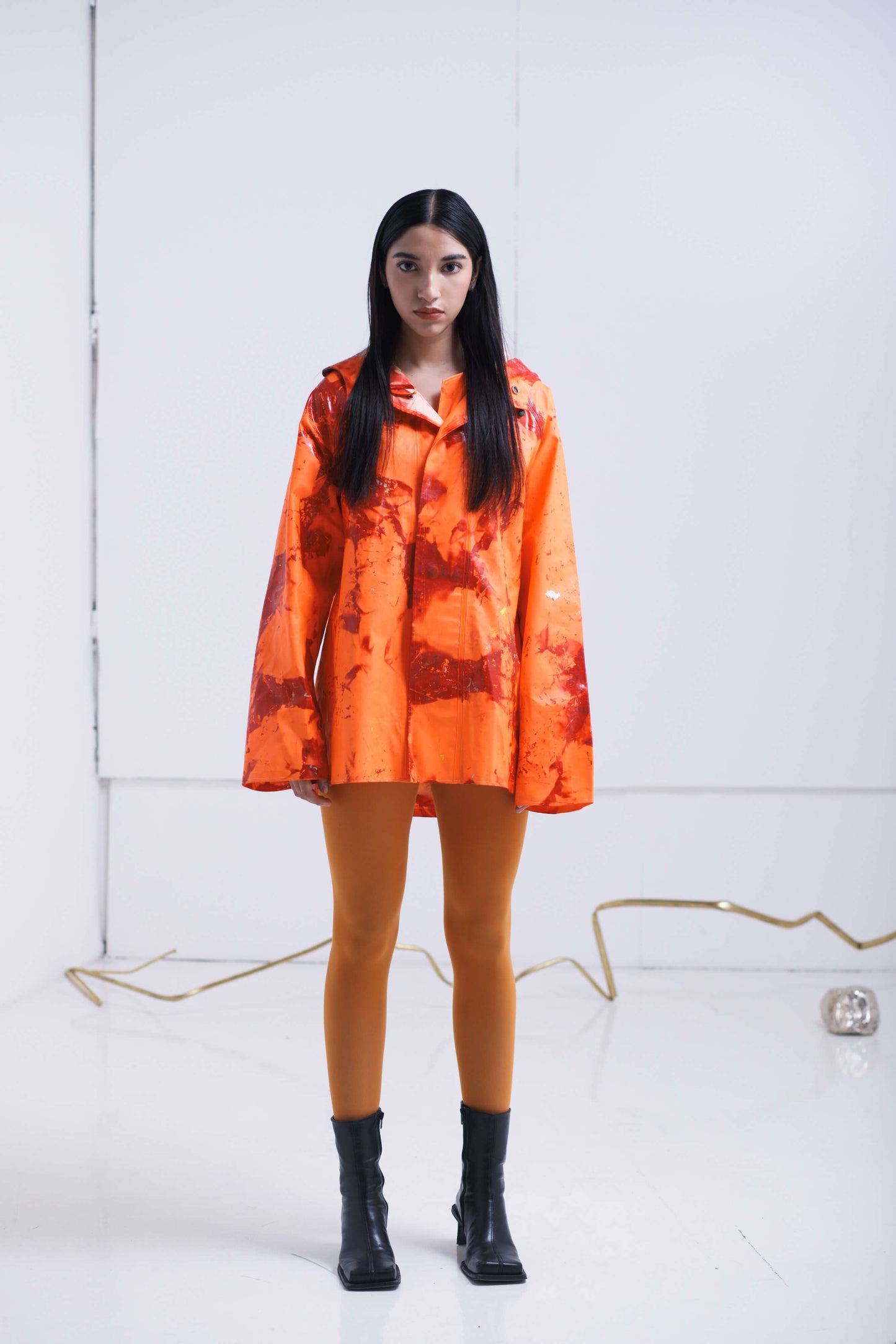 ORANGE RAINCOAT INTERVENED WITH SPRAY PAINT X ALDO CHAPARRO