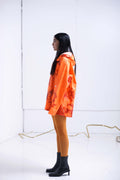 ORANGE RAINCOAT INTERVENED WITH SPRAY PAINT X ALDO CHAPARRO