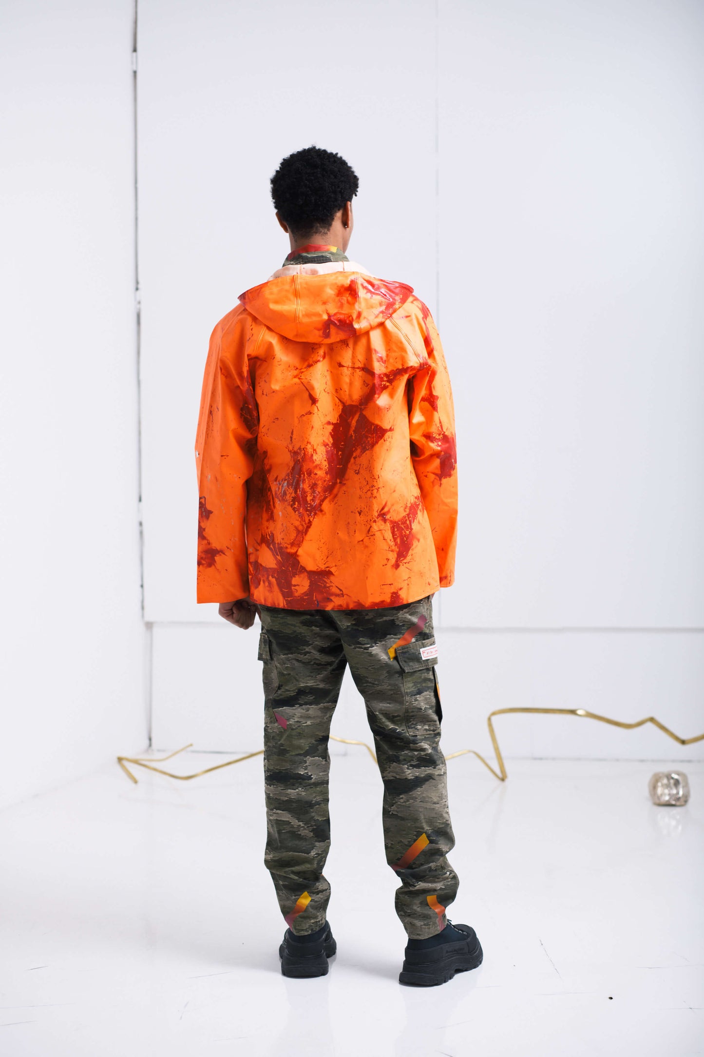 ORANGE RAINCOAT INTERVENED WITH SPRAY PAINT X ALDO CHAPARRO